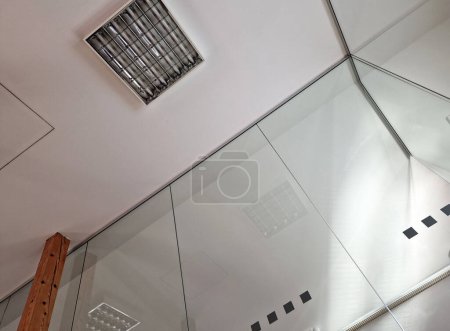 la habitación del ático con techo de placas de yeso se apoya en vigas de madera de pino. estilo rústico con una partición de vidrio, luz