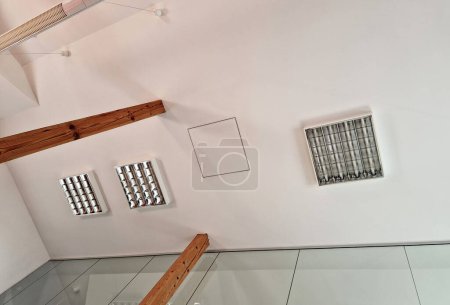 la pièce mansardée avec plafond en placoplâtre est soutenue par des poutres en bois de pin. style rustique avec cloison en verre, lumière