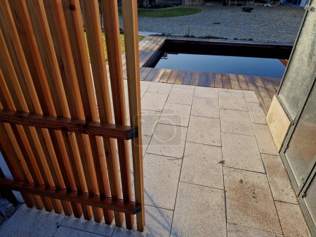 Téléchargez les photos : Après le sauna, vous devez sauter dans l'eau froide de la piscine naturelle avec purification de l'eau calcaire sans chlore. Biotope d'eau naturelle avec vestiaire, cabine - en image libre de droit