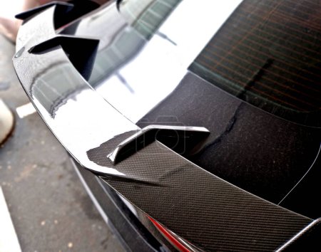 Téléchargez les photos : L'aile en carbone de la voiture aide à charger l'essieu arrière des roues sur la route. sport homologué modifications originales de voitures. pointe d'échappement. - en image libre de droit