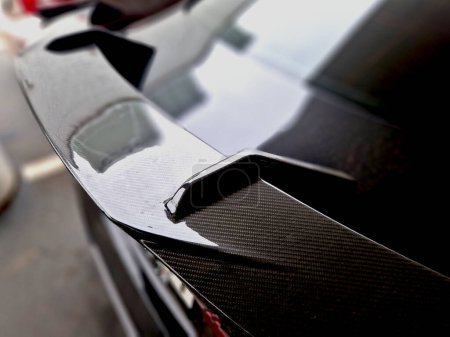 Der Carbon-Druckflügel des Autos hilft, die Hinterachse der Räder auf die Straße zu laden. Sport homologierten Original-Modifikationen von Autos. Auspuffspitze.