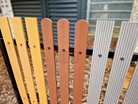 model fence made of plastic planks with different end shapes and wood-imitating colors. choice according to taste of customer who does not want to worry about painting the fence and can do recycled