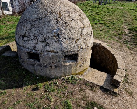 dome-shaped concrete circular fortress is slightly above ground. a trench is dug around it for entry from the back. gun emplacements and an observation post on hill. providing protection 