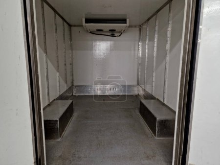 camión refrigerado interior está aislado e higiénicamente blanco para el transporte de mercancías y alimentos refrigerados, carne, para operaciones de cocina. alquiler de furgoneta de reparto, envío, servicio, puerta abierta, muelle