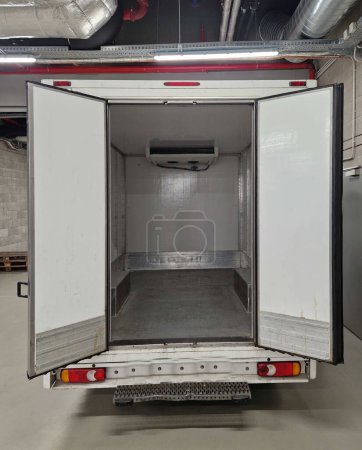 interior refrigerated truck is insulated and hygienically white for transporting goods and refrigerated food, meat, for kitchen operations. rental of delivery van, shipment, service, open door, dock