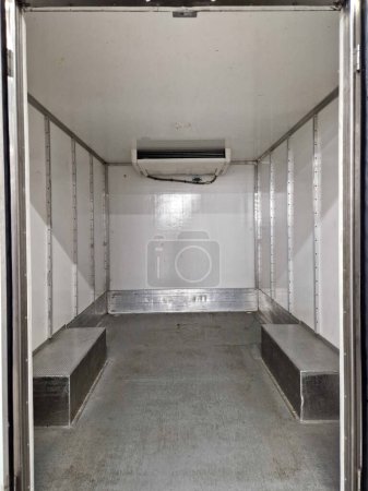 interior refrigerated truck is insulated and hygienically white for transporting goods and refrigerated food, meat, for kitchen operations. rental of delivery van, shipment, service, open door, dock