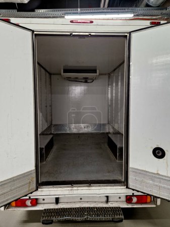 camión refrigerado interior está aislado e higiénicamente blanco para el transporte de mercancías y alimentos refrigerados, carne, para operaciones de cocina. alquiler de furgoneta de reparto, envío, servicio, puerta abierta, muelle