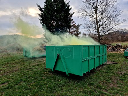 a container with chemical toxic waste from which green smoke comes out. radioactive waste in a bio-waste container. one of the drivers is bothering you with the smell. composting, military smokestack,
