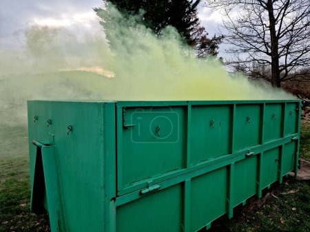 ein Behälter mit chemischen Giftabfällen, aus dem grüner Rauch austritt. Radioaktiver Abfall in einem Biomüllbehälter. Einer der Fahrer stört sich am Geruch. Kompostierung, militärischer Schornstein,