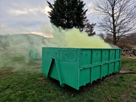 a container with chemical toxic waste from which green smoke comes out. radioactive waste in a bio-waste container. one of the drivers is bothering you with the smell. composting, military smokestack,