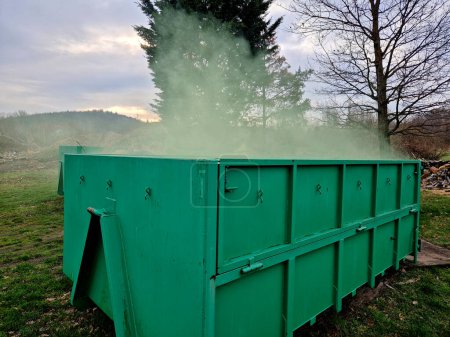 un recipiente con residuos tóxicos químicos de los que sale humo verde. residuos radiactivos en un contenedor de biorresiduos. Uno de los conductores te está molestando con el olor. compostaje, chimenea militar,