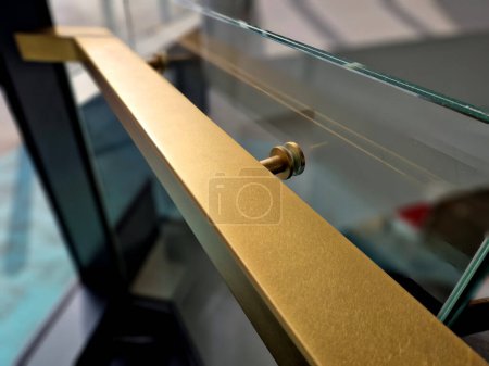  bord du verre collé de la rambarde recouvert d'une bande en forme de U. garnitures transparentes de la rampe en tube d'acier inoxydable brillant plié. entrer dans le bâtiment