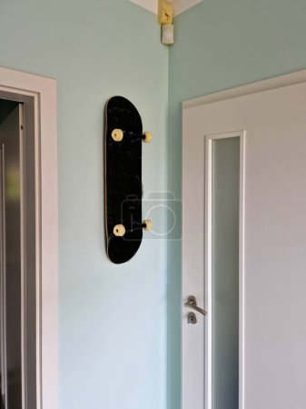 a skateboard attached to the wall of the room. the teenager loves skateboarding and therefore has a decoration on the wall. sports clubhouse