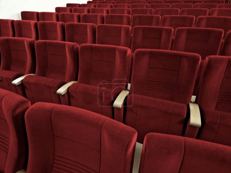 rows of padded seats. the seats are folding rows of armchairs with armrests are attached to the floor in an amphitheater slope to the stage. scarlet suede fabric