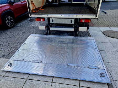 Photo for Is a very robust medium-duty column lift with a long foldable platform, suitable for handling pallets with a pallet jack. The folded platform can be lowered below the vehicle floor, to allow - Royalty Free Image