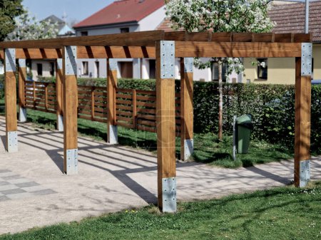 terrace with wooden pergola and plexiglass roof. vines are straining, crawling under the beams. garden or park. sitting with dry wall wine region. restaurant countryside france, truss
