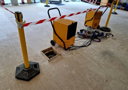 drying the concrete floor with electric building dryers. accelerates the progress of work in the interior. safety belt with stripes.