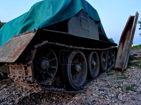  tank crashed into a steel pillar on a sandy bank after an unsuccessful crossing of the river bed. an invasion force cloaked in an anti-drone tarp, wheels