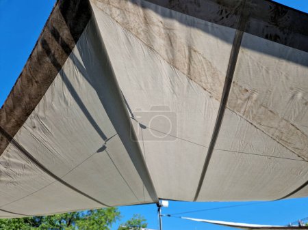 parasol, awning, folding tarpaulin against the sun is rolled up into a roll hanging in space above the terrace according to the need and strength of wind using a weather station with anemometer, sky