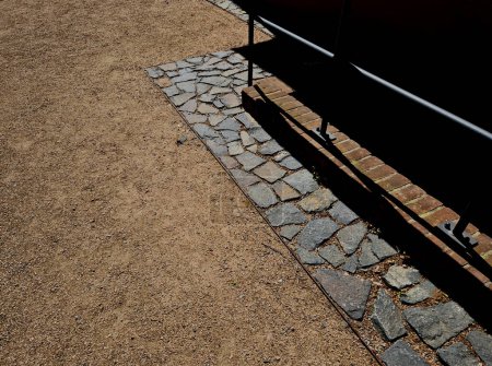Steinplatten säumen den Gehweg in der Nähe des Hauses. Schotterweg beim Parkplatz im Hinterhof