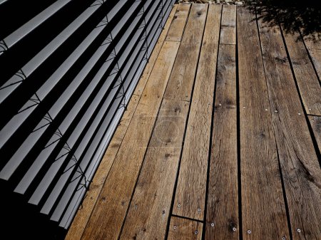 Photo for Impregnation of the terrace with oil paint. The color changes before painting and after application. the planks have a shiny and glaze and the structure of the wood is emphasized. weather protection - Royalty Free Image