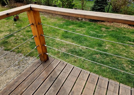 Terrace fencing, railings of metal pipes filled with steel cables cable mesh. fencing wire stainless steel fence. wooden floor, dance floor in the park, sunrise, cold day, winter