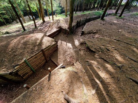 Verzweigte Grabenwege vertiefen sich in die bewaldete Landschaft. Die Beplankung der Wände schützt die Soldaten davor, vom Boden überrollt zu werden. Museum der Kriegsstrategie