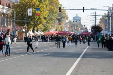 Téléchargez les photos : Chisinau, Moldavie - 15 octobre 2022 : Les gens marchent le long de l'avenue Stefan cel Mare le jour férié de la ville. Concentration sélective. - en image libre de droit