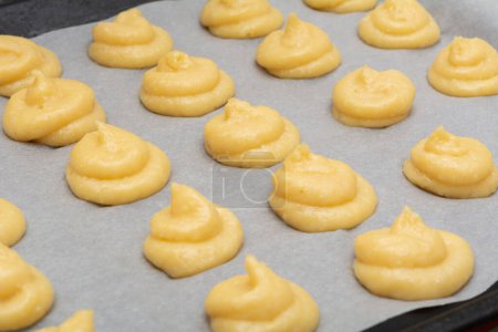 Foto de Puffs de queso francés. Gougeres Pasteles franceses en una sartén goteante antes de hornear - Imagen libre de derechos