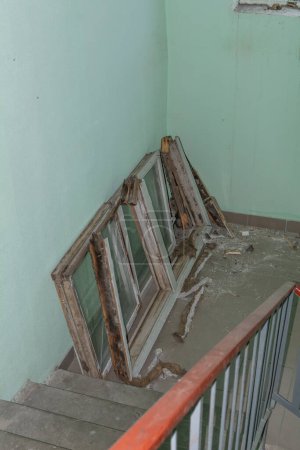 Photo for Replacement of old windows. Replacement of old wooden windows with plastic PVC ones. Old wooden window frames on the site of an apartment building. Installation - Royalty Free Image