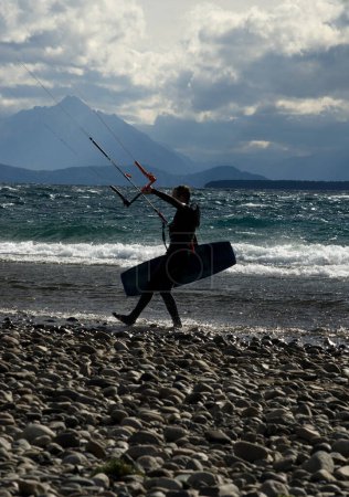 Foto de Kitesurf atleta salir del agua, con lago y montañas - Imagen libre de derechos