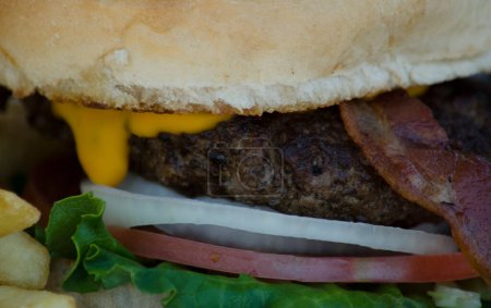 Foto de Hamburguesa casera con queso de tocino y tomate, primer plano de hamburguesa recién cocida. foto gastronómica - Imagen libre de derechos