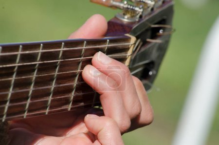 Téléchargez les photos : Woman's hand making a chord on the guitar, close up shot - en image libre de droit