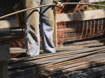 Foto de Obrero de la construcción agarrando un hierro doce. con overoles de trabajo - Imagen libre de derechos