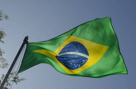 Foto de Bander de brasil flameando en el viento con cielo azul - Imagen libre de derechos