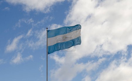 Foto de Bandera argentina sobre cielo azul en mástil alto - Imagen libre de derechos