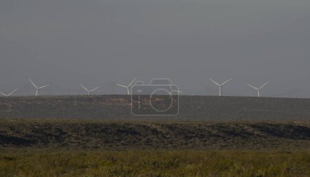 windmills with wind energy turbines in the countryside to generate clean energy