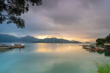 Photo for Romantic view of sunrise with crimson clouds. Beautiful lakes and mountains. Chaowu Pier, Sun Moon Lake National Scenic Area. Nantou County, Taiwan - Royalty Free Image