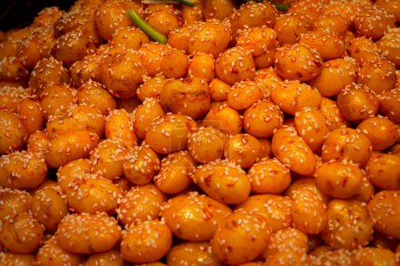 Foto de Primer plano de papas doradas de sésamo, una popular comida callejera en Wuchang, China. La imagen captura ricas texturas y colores. - Imagen libre de derechos
