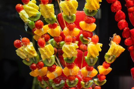 Photo for A vibrant display of fresh, smooth candied fruit skewers, a popular street food in Wuchang , China. This image captures the richness of texture and color. - Royalty Free Image