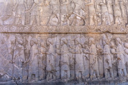 Detaillierte Steingravuren, die Menschen und Tiere in Bewegung darstellen. Ein Blick in die antike Kunst mit ihren komplexen Designs und Geschichten, Persepolis, Iran.