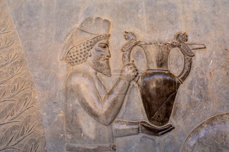 Detaillierte Schnitzerei einer edlen Figur mit einem verzierten Gefäß, die die komplizierte Kunst des antiken Persien zeigt. Hervorhebung des handwerklichen Könnens. Persepolis, Iran.