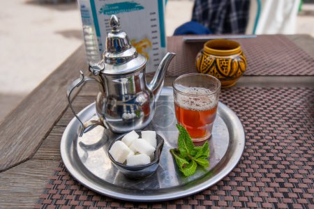 Traditional Moroccan mint tea iced with white sugar cubes is a popular refreshment in Essaouira, Morocco.
