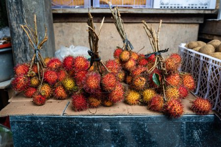 Foto de Fresh rambutan fruit sold at the market in daylight, horizontal - Imagen libre de derechos