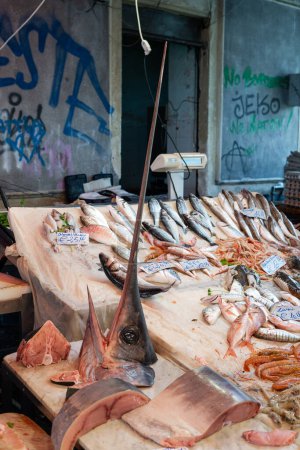 Foto de Pescado fresco con cabeza de pez espada grande vendido en un mercado de pescado italiano en Sicilia - Imagen libre de derechos