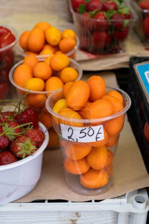 Foto de Fruta kumquat de naranja fresca vendida en una taza en un mercado local en Grecia - Imagen libre de derechos
