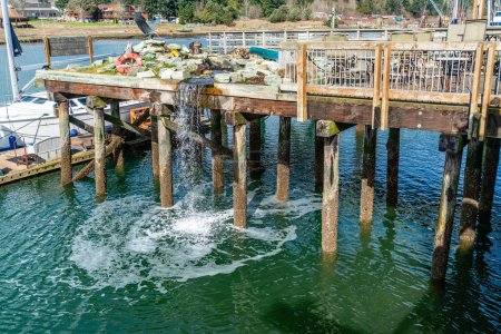 A waterfall flows down from a pier in La Conner, Washington.