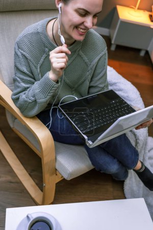 Foto de Consulta psicológica en línea, videollamada con un ordenador portátil, una mujer en un suéter se comunica a través de un enlace de vídeo. Emocional mujer de mediana edad - Imagen libre de derechos
