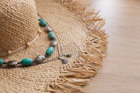 Téléchargez les photos : Chapeau de paille femme, perles vintage turquoise et pendentif coquille argentée reposent sur une table en bois, accessoires d'été - en image libre de droit