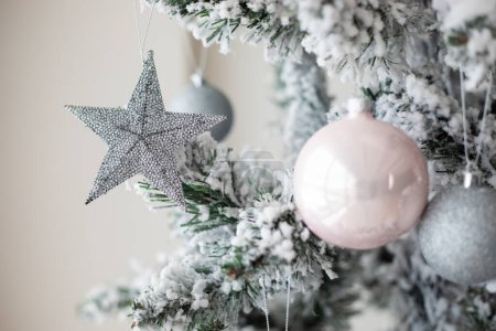 Téléchargez les photos : Jouets de Noël suspendus à un sapin de Noël, boules et étoiles avec étincelles, neige artificielle - en image libre de droit